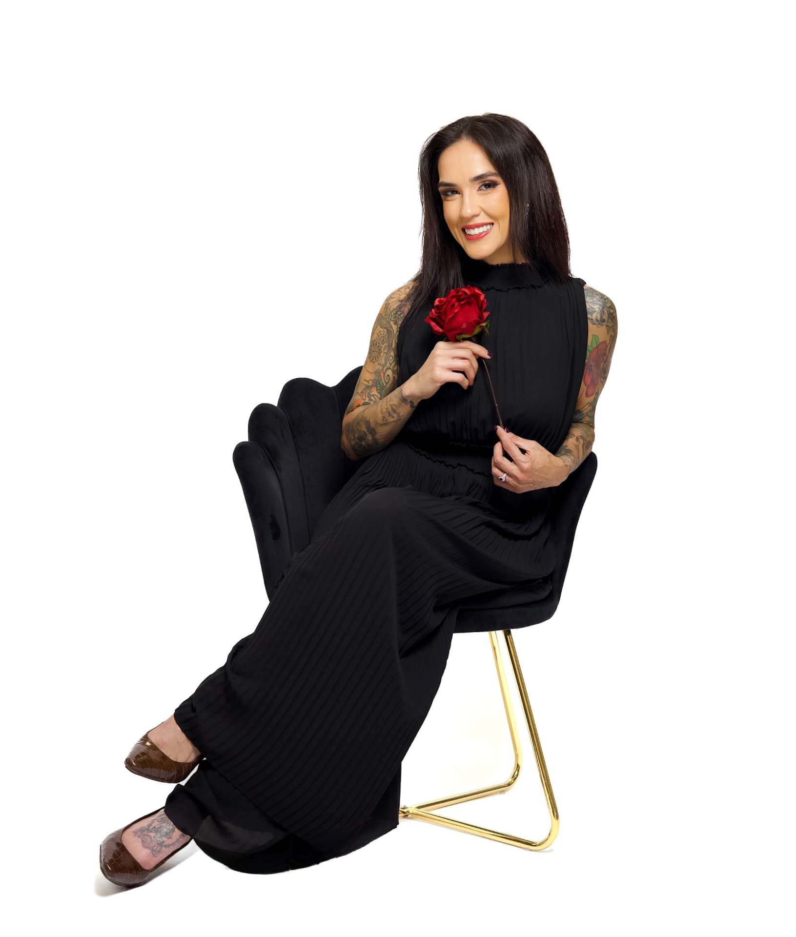 Dani seated in a black dress holding a red rose.